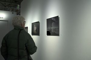 Women looking at photography that is printed on aluminum, which is hanging on the wall