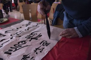 Person practicing Chinese caligraphy